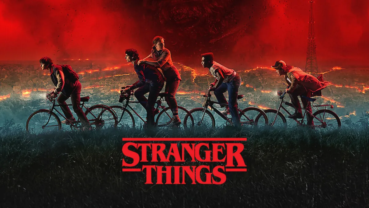 Los protagonistas de Stranger Things en bicicleta por una calle de Hawkins de noche
